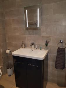 a bathroom with a white sink and a mirror at Primrose House in St Ives