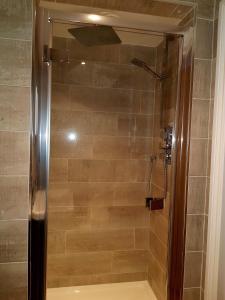 a shower with a glass door in a bathroom at Primrose House in St Ives