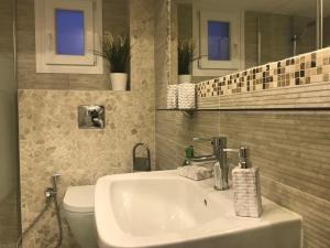 a bathroom with a sink and a toilet at Riviera Home in Perea +42 photos