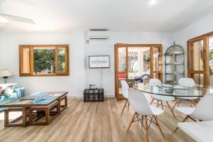 uma sala de estar com uma mesa de vidro e cadeiras brancas em Travel Habitat Benicassim em Benicàssim