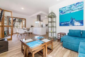 uma sala de estar com um sofá azul e uma mesa em Travel Habitat Benicassim em Benicàssim