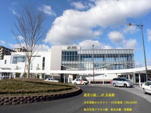 名取市Grand Hotel Staymore -Adult Only的一座白色的大建筑,前面有汽车停放