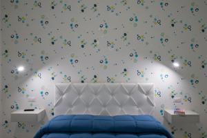 ein Schlafzimmer mit einem blauen Bett mit Konfetti an der Wand in der Unterkunft Casa Loreto, Agerola in Agerola