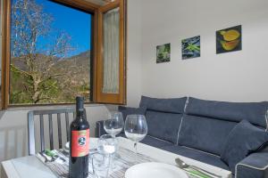 a bottle of wine sitting on a table with two wine glasses at Casa Loreto, Agerola in Agerola +10 photos