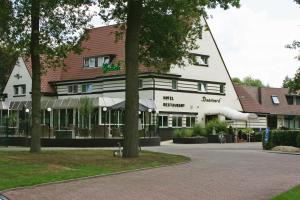 un grand bâtiment blanc avec un arbre en face dans l'établissement Fletcher Hotel Restaurant Dinkeloord, à Beuningen