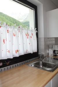cocina con fregadero y ventana en Residence Flora, en Solda