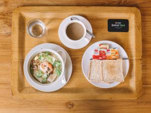 a tray with a plate of food and a cup of coffee at Baan Tah On The Sea in Bang Sare