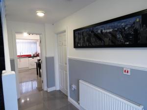 a living room with a large television on the wall at StayNEC Moat House Birmingham - For Company, Contractor and Leisure Stays - NEC, HS2, JLR, Airport in Birmingham