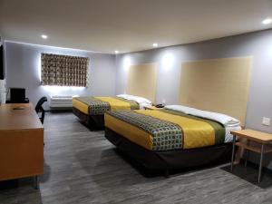 a room with two beds in a room with a window at Regal Inn in Los Angeles