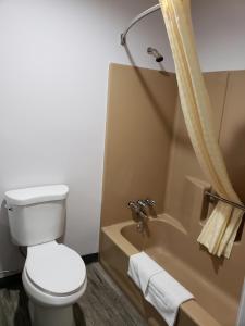 a bathroom with a toilet and a tub and a sink at Regal Inn in Los Angeles
