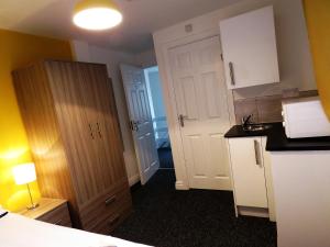a small kitchen with white cabinets and a counter top at StayNEC Moat House Birmingham - For Company, Contractor and Leisure Stays - NEC, HS2, JLR, Airport in Birmingham