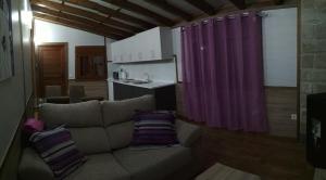 a living room with a couch and a purple curtain at Bungalows Cantia in Suances