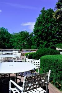 a white table and chairs with trees and bushes at Hôtel des Pyrénées in Saint-Jean-Pied-de-Port
