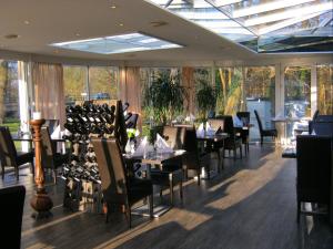 un comedor con mesas, sillas y ventanas en Fletcher Hotel Restaurant Dinkeloord en Beuningen
