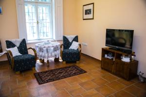 een woonkamer met een tv en 2 stoelen en een tafel bij Kolar Apartment in Subotica