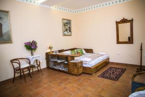 een slaapkamer met een bed, een tafel en een spiegel bij Kolar Apartment in Subotica