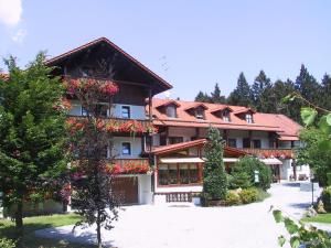 un edificio con flores a un lado. en Waldpension Jägerstüberl en Bad Griesbach