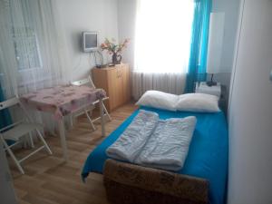 mały pokój z łóżkiem i stołem w obiekcie Pokoje Rybacka 5 w mieście Krynica Morska