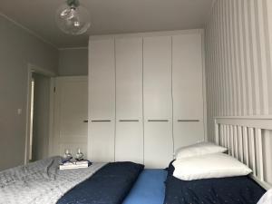 - une chambre avec un lit et une grande armoire blanche dans l'établissement Apartament 27, à Gdynia