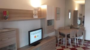 - un salon avec une télévision et une table avec des chaises dans l'établissement Appartamento Beautiful Panorama, à Rapallo