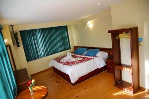 a bedroom with a large bed and a table at Hotel Donde Marcelo in Baños