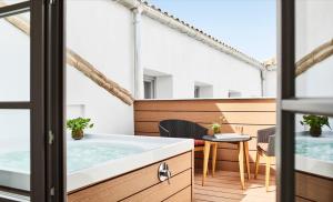 a bathroom with a bath tub and a table at Gran Hotel Inglés - The Leading Hotels of the World in Madrid