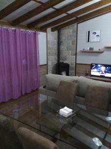 ein Wohnzimmer mit einem Sofa und einem Glastisch in der Unterkunft Bungalows Cantia in Suances
