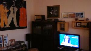 un soggiorno con TV a schermo piatto in una camera di Il Melograno a Borgo San Dalmazzo