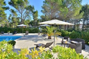 a patio with chairs and an umbrella next to a pool at MAM Mali in Vir