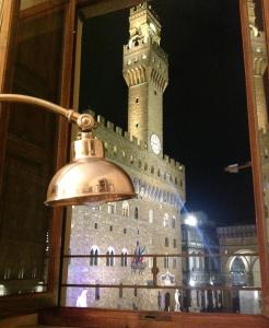 un grande edificio con torre dell'orologio di notte di Caterina apartment a Firenze