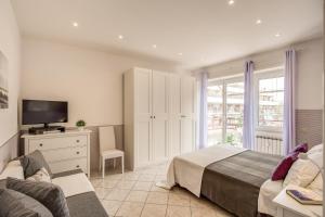a bedroom with a bed and a tv and a couch at Rome4Guest Ostia in Lido di Ostia