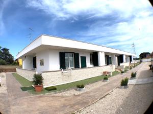 ein weißes Gebäude mit Topfpflanzen davor in der Unterkunft Residence Pegaso in Nettuno