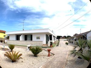 ein weißes Gebäude mit Pflanzen davor in der Unterkunft Residence Pegaso in Nettuno