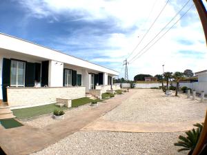 un bâtiment avec une rangée de bancs devant lui dans l'établissement Residence Pegaso, à Nettuno