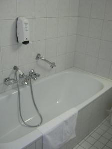 La salle de bains est pourvue d'une baignoire blanche et d'une douche. dans l'établissement Fletcher Hotel Restaurant Dinkeloord, à Beuningen