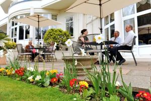 a group of people sitting on the porch of a house at Queens Hotel & Spa Bournemouth in Bournemouth