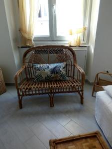 ジェノヴァにあるCasa del Cioccolatteの窓付きの部屋に座る籐のベンチ