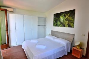 トッリ・デル・ベーナコにあるGreenery Loftの小さなベッドルーム(白いベッド1台、絵画付)