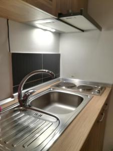 un lavandino in acciaio inossidabile in una piccola cucina di Apartman Galerija a Novi Sad