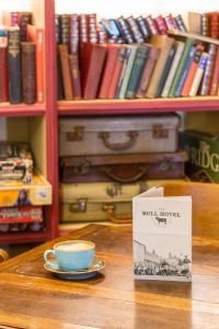 a cup of coffee sitting on a table with a book at The Bull Hotel in Olney