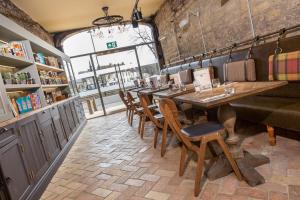 uma sala de jantar com uma mesa longa e cadeiras em The Bull Hotel em Olney