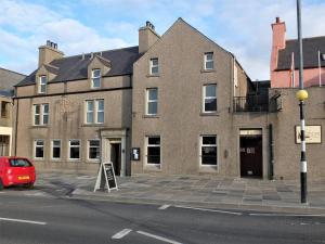 un edificio de ladrillo con un cartel delante en The Shore, en Kirkwall