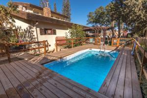 a pool with a wooden deck and a swimming poolvisor at Desert Bird Guest House in Arad