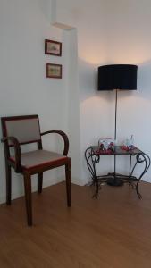 Zimmer mit einem Stuhl und einem Tisch mit einer Lampe in der Unterkunft Manoir de la Ville Marie in Hirel