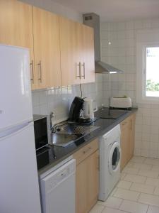 a kitchen with a sink and a washing machine at El Piso Del Sol in Fuengirola