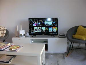 a living room with a tv on a white desk at El Piso Del Sol in Fuengirola