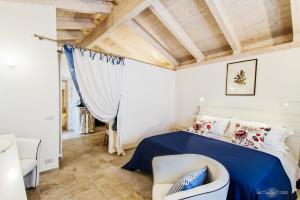 a bedroom with a blue bed and a chair at Borgo Noci in Noci