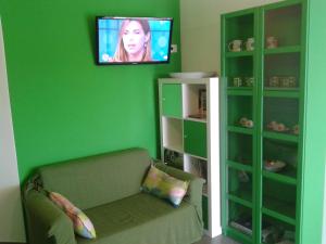 贾迪尼-纳克索斯Appartamenti Calliope e Silvia, Giardini Naxos的绿色的客房设有沙发和平面电视。