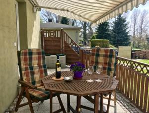 einen Holztisch mit 2 Stühlen und eine Flasche Wein in der Unterkunft Apartment Charlotte in Zirkow