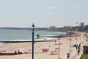 a beach with people on the sand and the ocean at Beach Lodge in Bournemouth